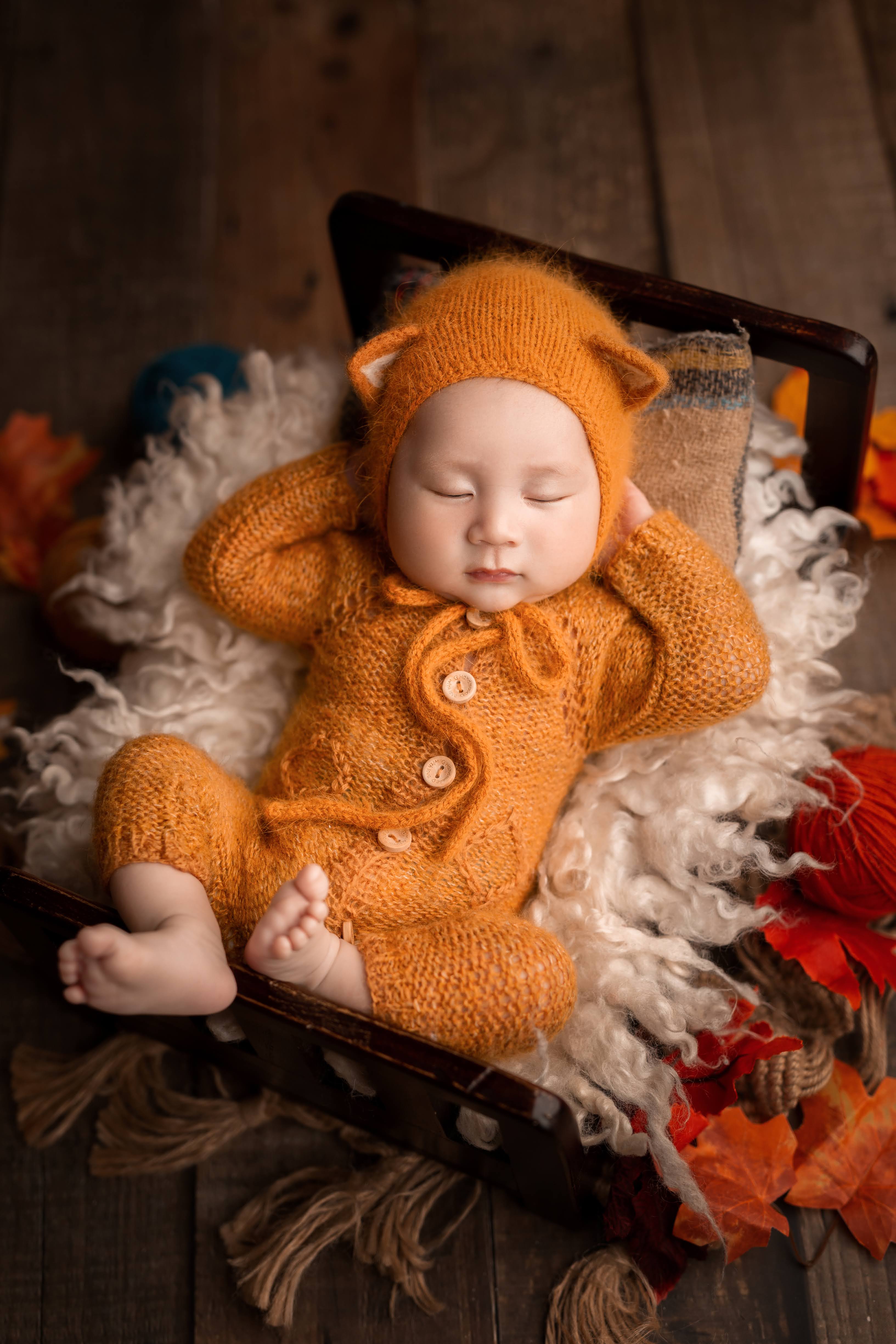 Chụp ảnh newborn bé bodysuit cam gấu mùa thu lá phong tại Teddy Studio